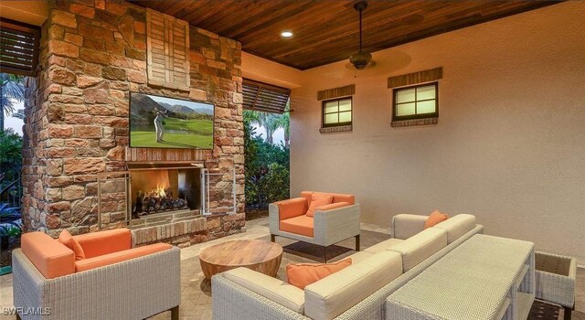 view of patio with an outdoor living space with a fireplace