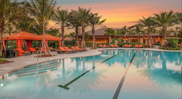 community pool with a gazebo and a patio