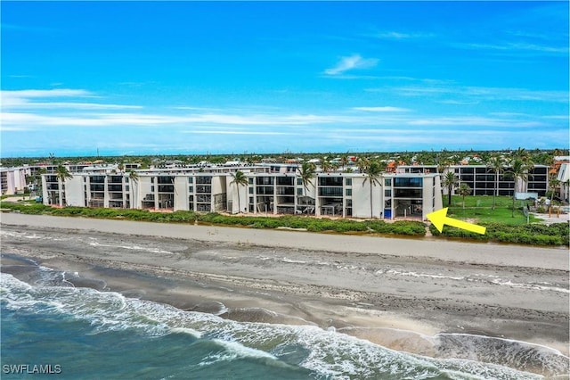 view of building exterior featuring a water view and a view of the beach