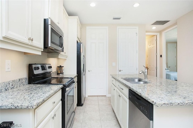 kitchen featuring sink, light tile patterned floors, an island with sink, white cabinetry, and stainless steel appliances