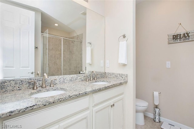 bathroom with tile patterned floors, a shower with door, vanity, and toilet