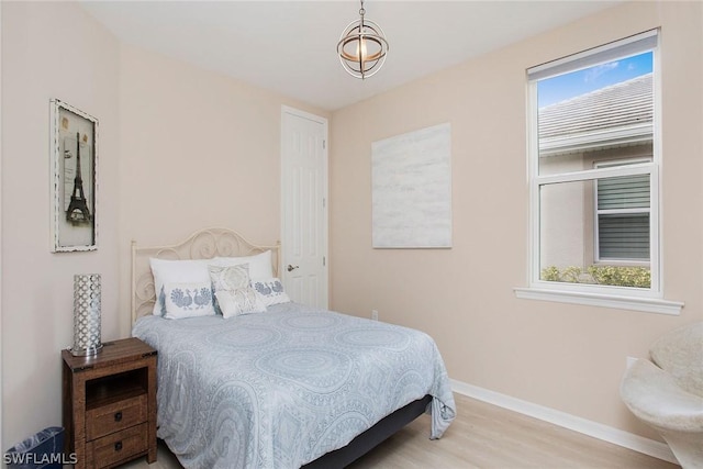 bedroom with multiple windows and light hardwood / wood-style flooring