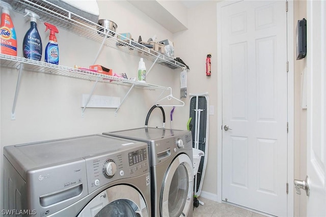 laundry room featuring washing machine and dryer and light tile patterned floors