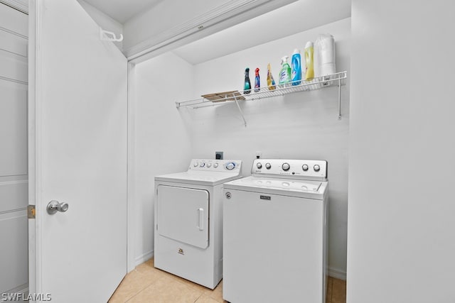 laundry area with washer and clothes dryer and light tile floors