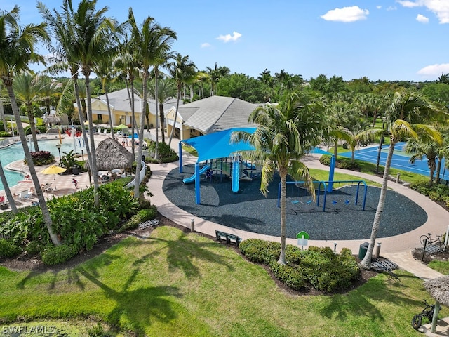 view of playground with a community pool and a lawn