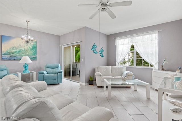 living room with ceiling fan with notable chandelier