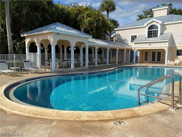 view of pool with french doors and a patio area