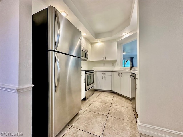 kitchen featuring light tile patterned flooring, recessed lighting, stainless steel appliances, white cabinets, and light countertops