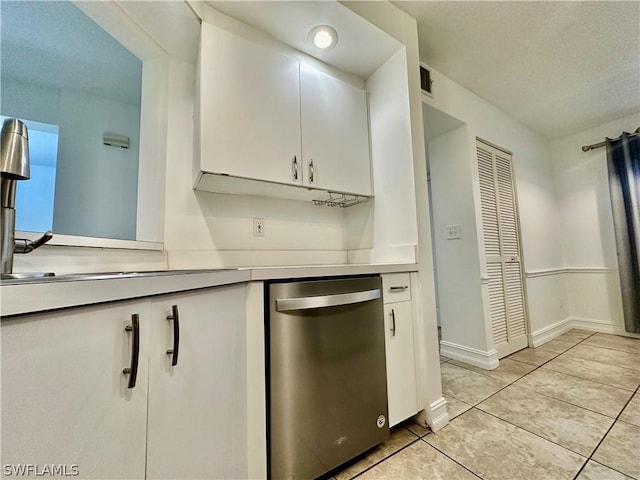 kitchen with light tile patterned floors, white cabinetry, baseboards, light countertops, and stainless steel dishwasher