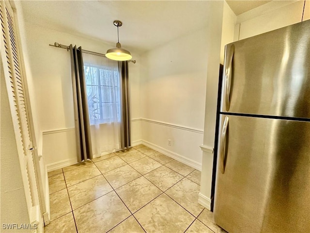 unfurnished dining area with light tile patterned floors and baseboards