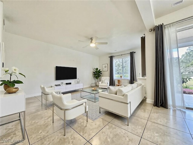 living room featuring light tile patterned floors, baseboards, visible vents, and a ceiling fan