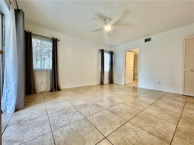 spare room with visible vents, ceiling fan, baseboards, and light tile patterned flooring