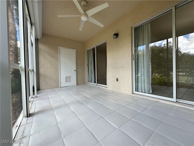 unfurnished sunroom featuring visible vents and a ceiling fan