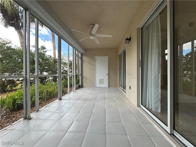 unfurnished sunroom featuring a ceiling fan