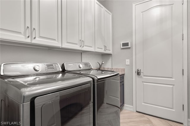 laundry area featuring cabinets and washing machine and clothes dryer