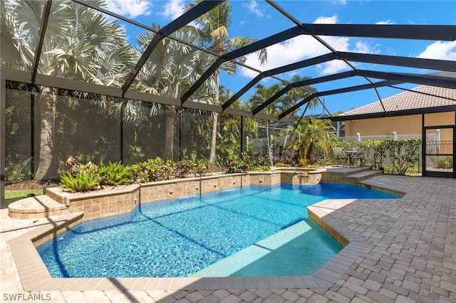 view of swimming pool featuring glass enclosure and a patio area