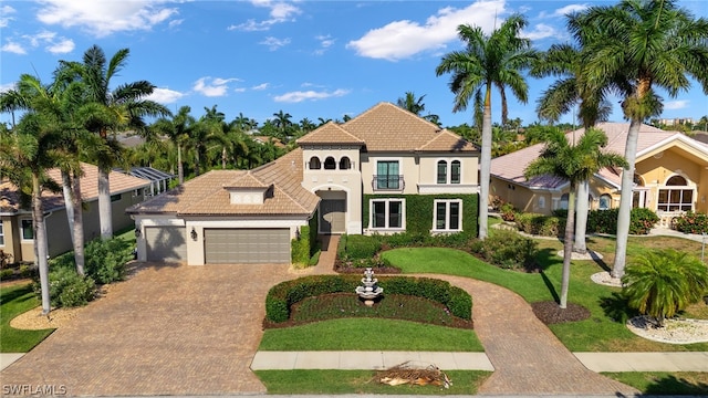 view of front of home with a balcony, a garage, and a front lawn