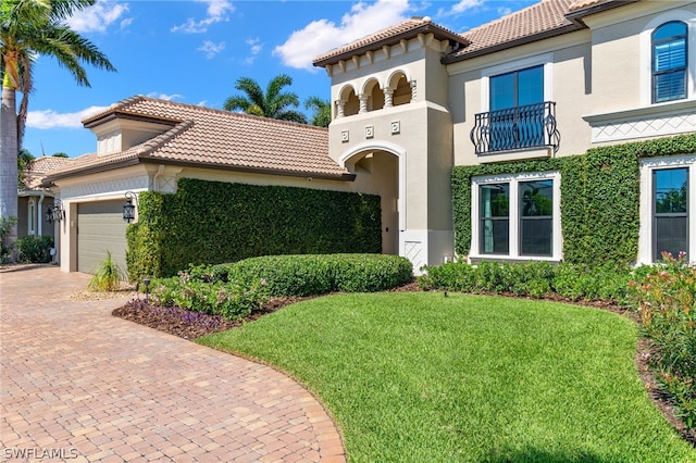 mediterranean / spanish-style home featuring a garage and a front yard