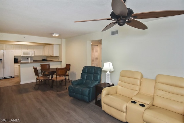 living room with ceiling fan and dark hardwood / wood-style flooring