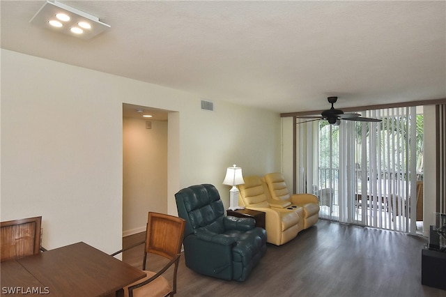 living room with ceiling fan and dark hardwood / wood-style flooring