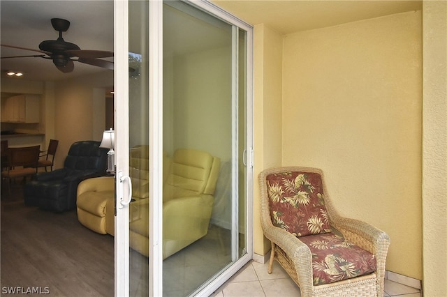 sitting room with light tile patterned floors and ceiling fan