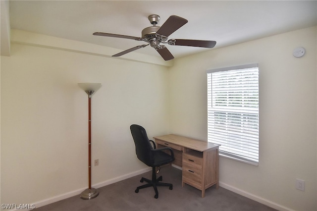 carpeted office space featuring plenty of natural light and ceiling fan