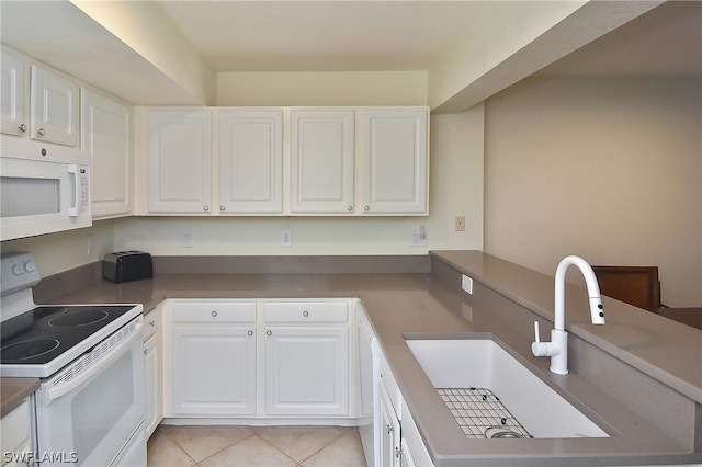 kitchen with kitchen peninsula, white appliances, sink, light tile patterned floors, and white cabinetry