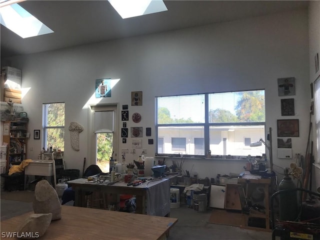 interior space featuring a skylight and high vaulted ceiling