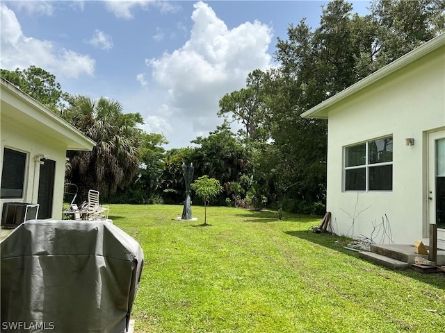 view of green lawn with view of scattered trees and central air condition unit