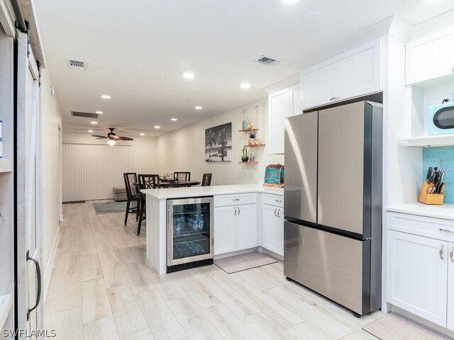 kitchen with white cabinetry, light wood-type flooring, stainless steel refrigerator, wine cooler, and ceiling fan