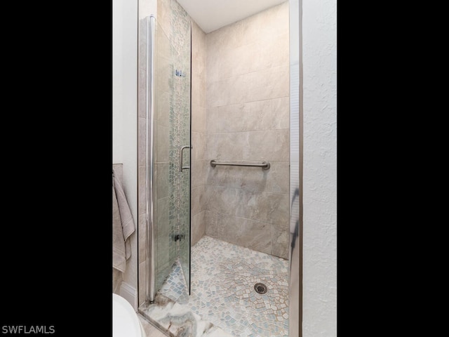 bathroom featuring a shower with door