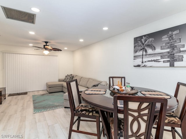 dining area with light hardwood / wood-style flooring and ceiling fan