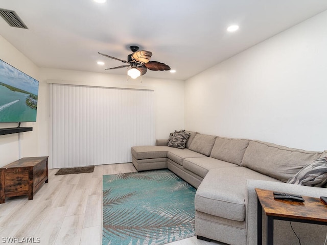 living room featuring light hardwood / wood-style flooring and ceiling fan