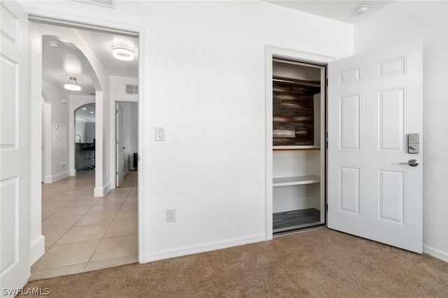 unfurnished bedroom with light tile patterned floors and a closet