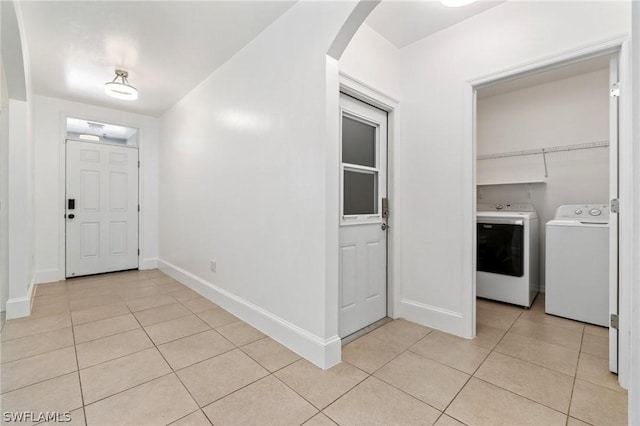 entryway with light tile patterned floors and washing machine and clothes dryer