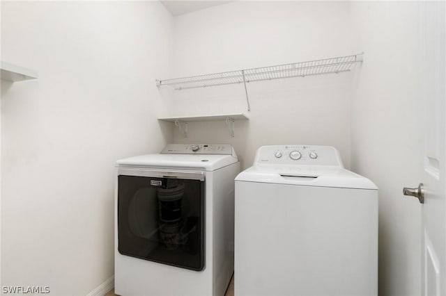 clothes washing area with separate washer and dryer