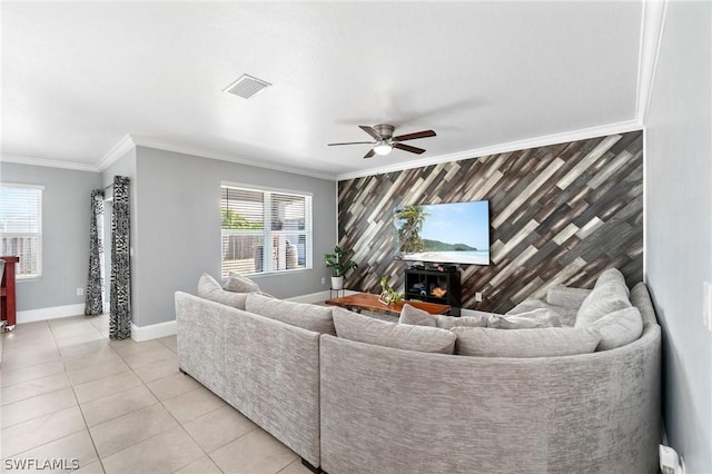 living room with ceiling fan, light tile patterned floors, crown molding, and wooden walls