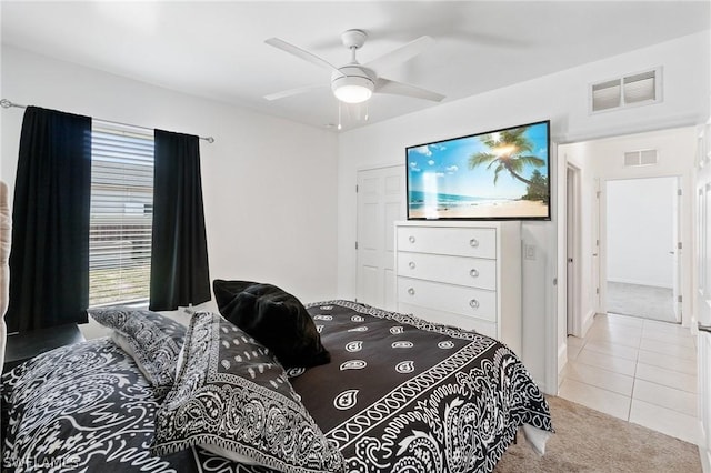 bedroom with ceiling fan and light carpet