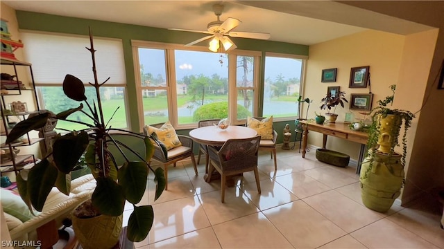 sunroom / solarium with a water view and ceiling fan