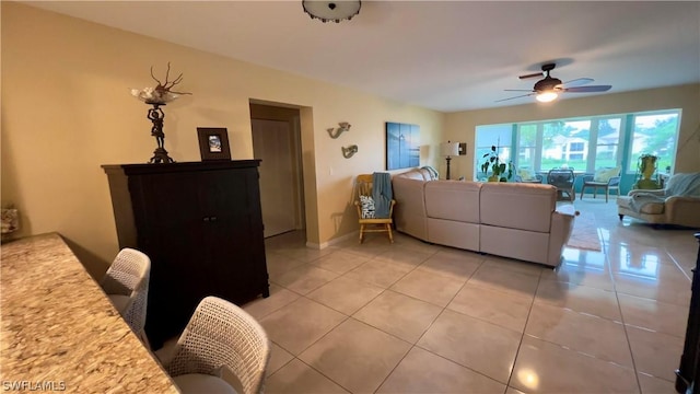 living room featuring tile patterned flooring and ceiling fan