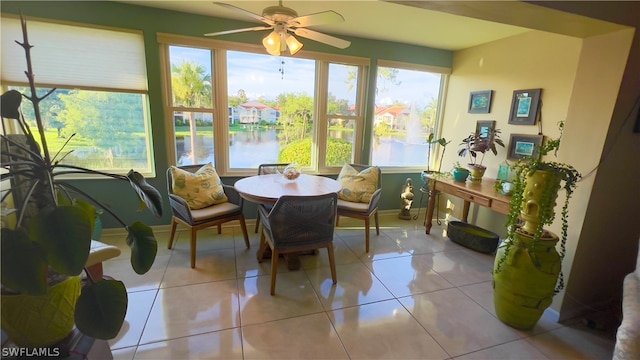 sunroom featuring a water view and ceiling fan