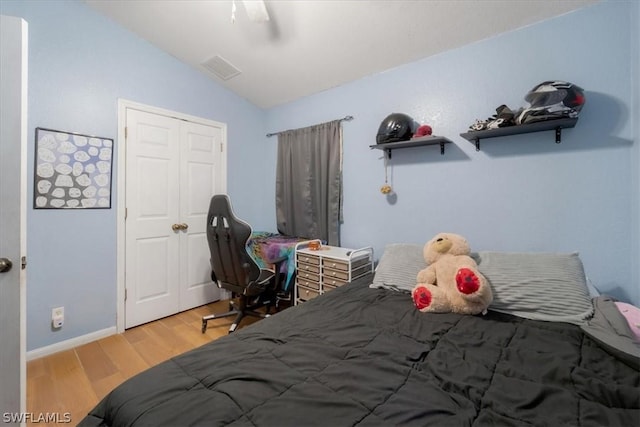 bedroom featuring vaulted ceiling, ceiling fan, light hardwood / wood-style floors, and a closet