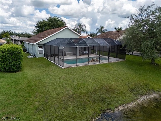 view of pool featuring a yard, glass enclosure, and a patio area