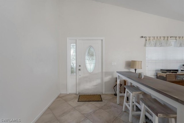 foyer with vaulted ceiling and light tile patterned floors