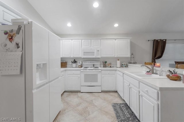 kitchen with sink, light tile patterned floors, kitchen peninsula, white appliances, and white cabinets