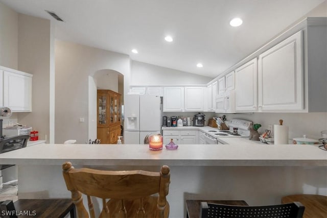 kitchen with white cabinetry, white appliances, and a kitchen bar