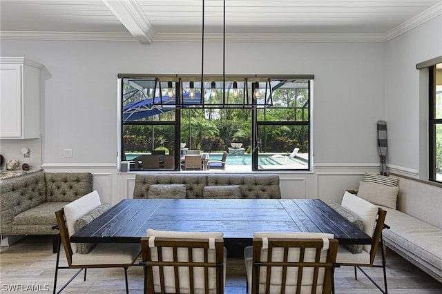 dining room featuring hardwood / wood-style floors, beamed ceiling, and ornamental molding