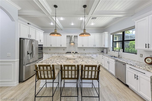 kitchen featuring light stone countertops, appliances with stainless steel finishes, white cabinets, a center island, and hanging light fixtures