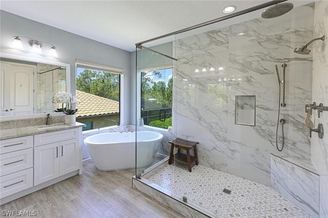 bathroom featuring hardwood / wood-style floors, vanity, and shower with separate bathtub