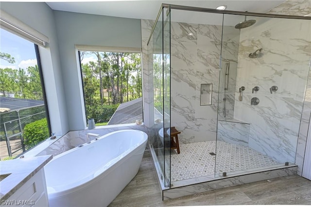 bathroom featuring hardwood / wood-style flooring, vanity, and shower with separate bathtub